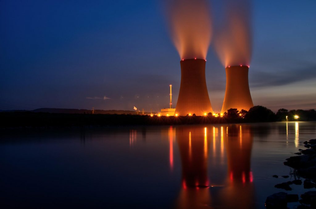 Energialaitos valaistuna iltahämärässä